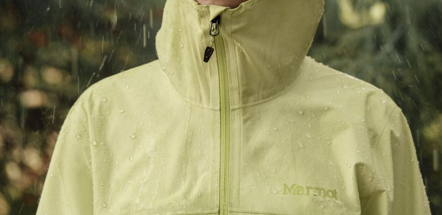 Frau mit aufgesetzter Kapuze im Regen.