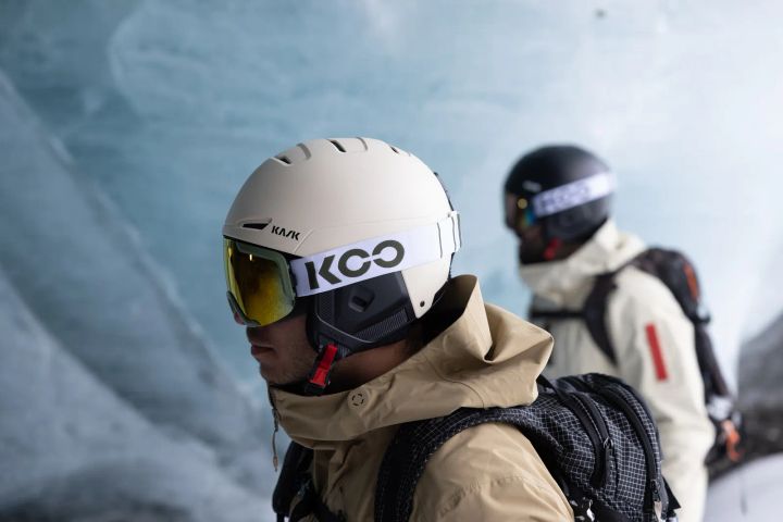 Freerider mit hellem KASK-Helm und gelb verspiegelter Skibrille in einer Gletscher-Eishöhle, dahinter eine zweite Person mit Helm