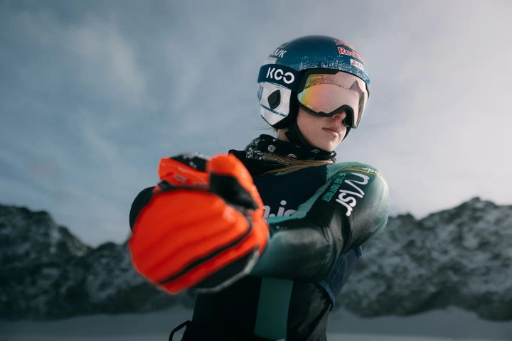 Skirennläuferin Lara Colturi mit KASK-Rennhelm und Skibrille streckt einen orangefarbenen Handschuh nach vorn