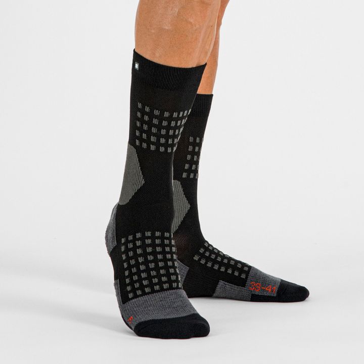 Beine in schwarz-grauen, halbhohen Sportsocken mit Noppenmuster, Studioaufnahme