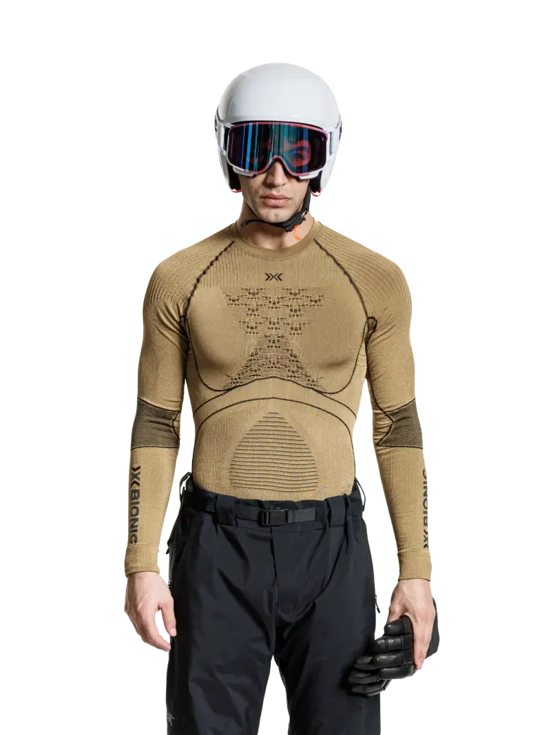 Skifahrer mit Helm und Skibrille im goldfarbenen Funktionsshirt