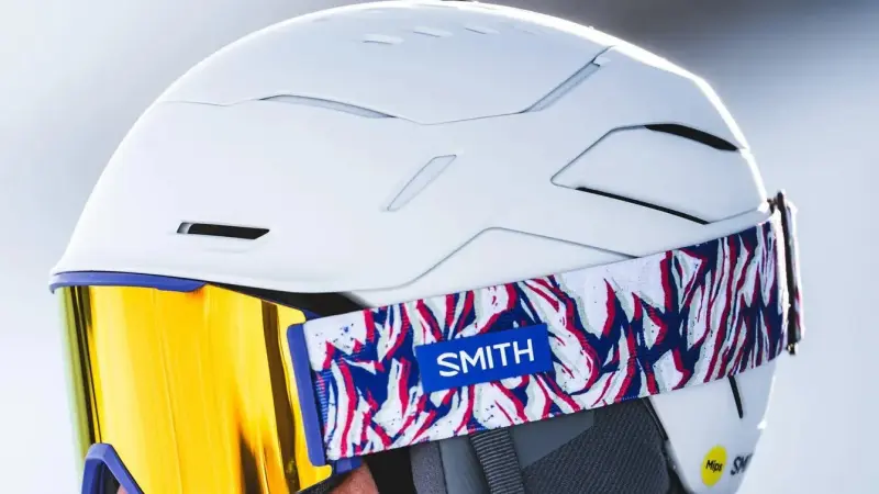 Skifahrer mit weißem Smith-Helm, hinten das gelbe Mips-Zeichen